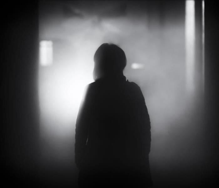 person silhouetted black and white in smoke